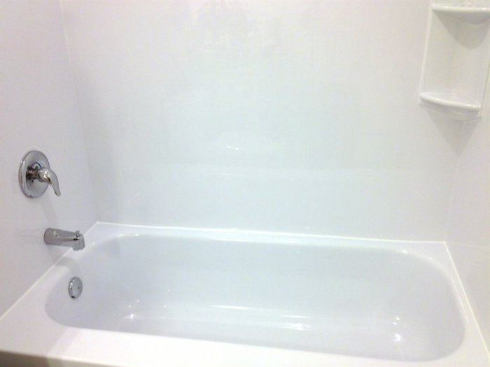 Newly installed custom tub liner with corner storage and Moen fixtures